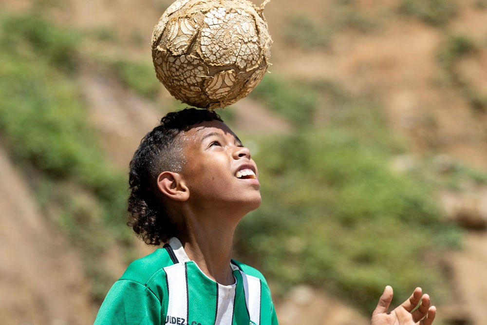 Partipantes del Programa Familias Fuertes. Un jóven juega con una pelota de fútbol.