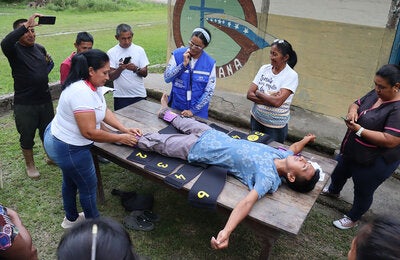 En encuentro de saberes en el estado Amazonas mientras se da instrucciones a las parteras indígenas tradicionales sobre cómo usar el traje antichoque no neumático