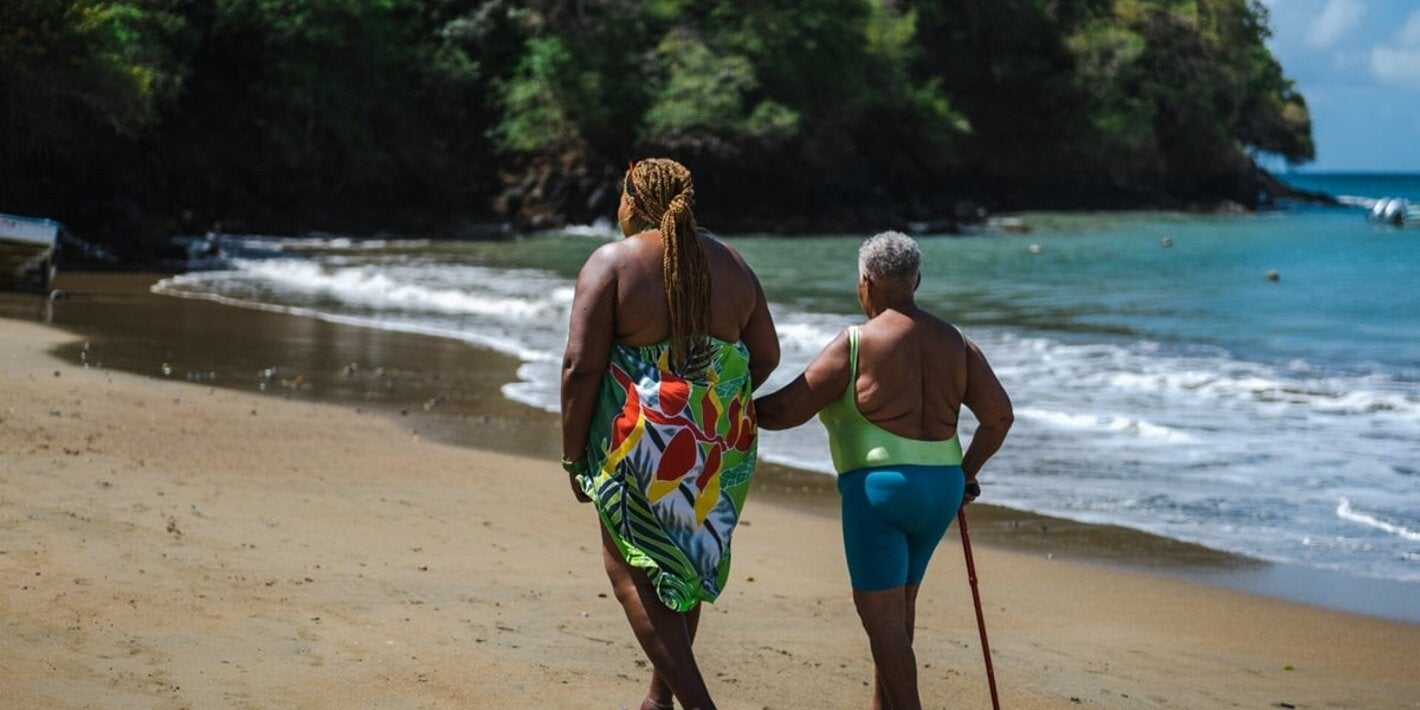 Arlene (en la parte izquierda de la imagen) se lleva a su madre siempre que puede en sus paseos a lo largo de la playa. Vivir en la localidad costera de Belle Garden (Tobago) les permite relajarse y hacer ejercicio.
