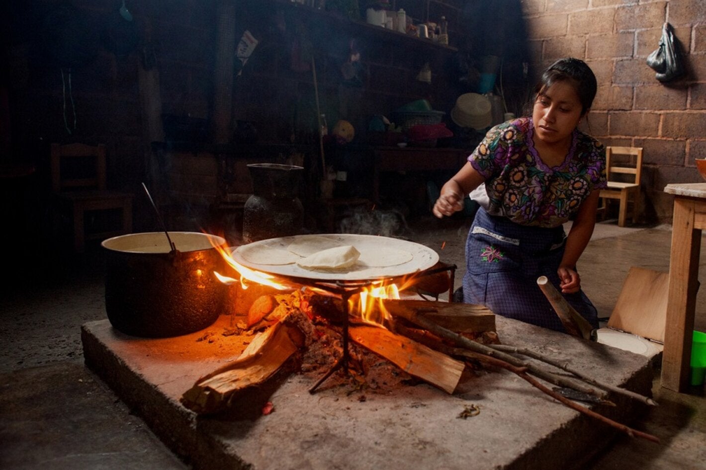 Mujer maya cocinando al fuego