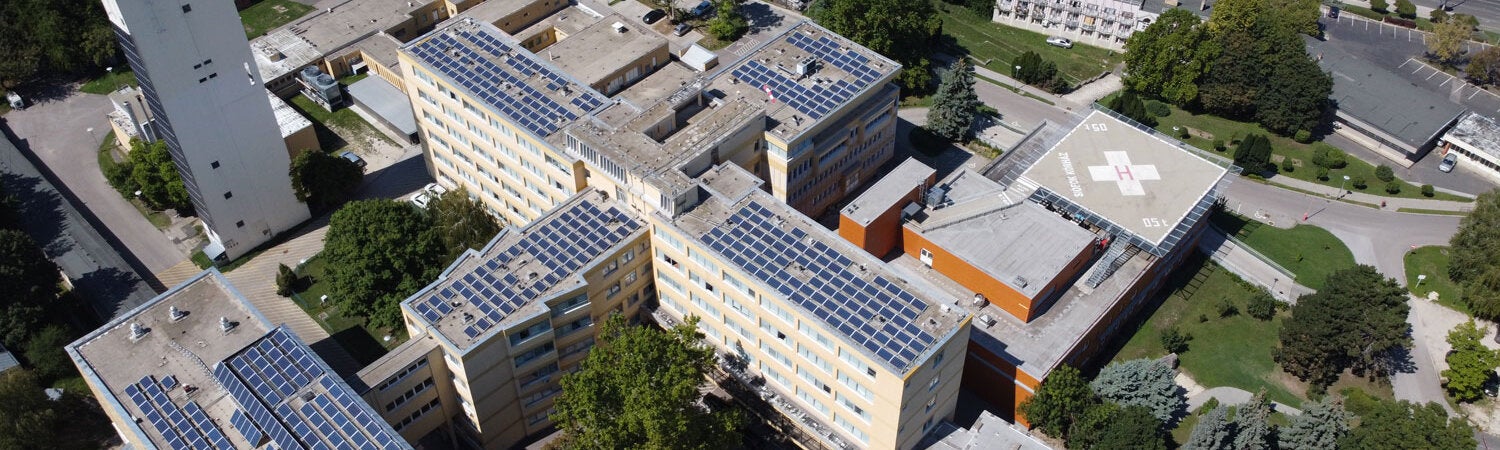 Renewable hospital. Aerial view hospital buildings with solar panels on the roof of in a nice green area.
