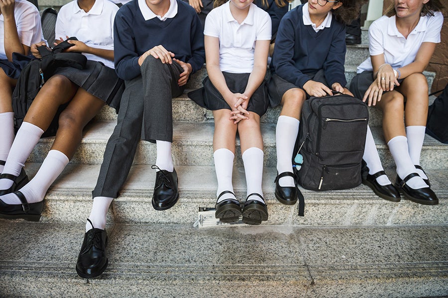 Group of students sitting on a row on a staircase.