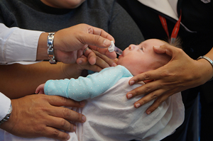 Baby getting immunization drops