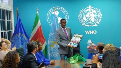 Dr. Yitades Gebre received a photo collage from the staff as a farewell gift. He has served in Suriname for four years  and will continue his career in Barbados.