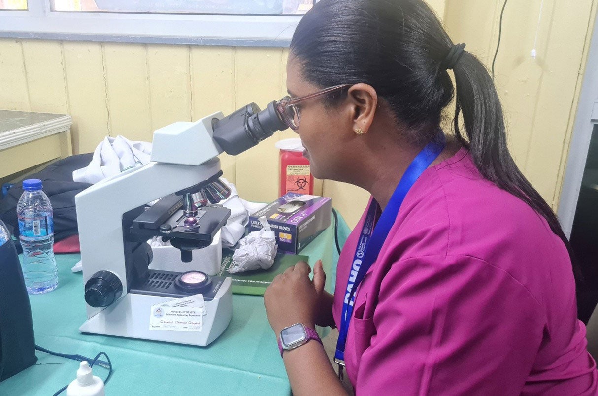 Mujer mirando por un microscopio