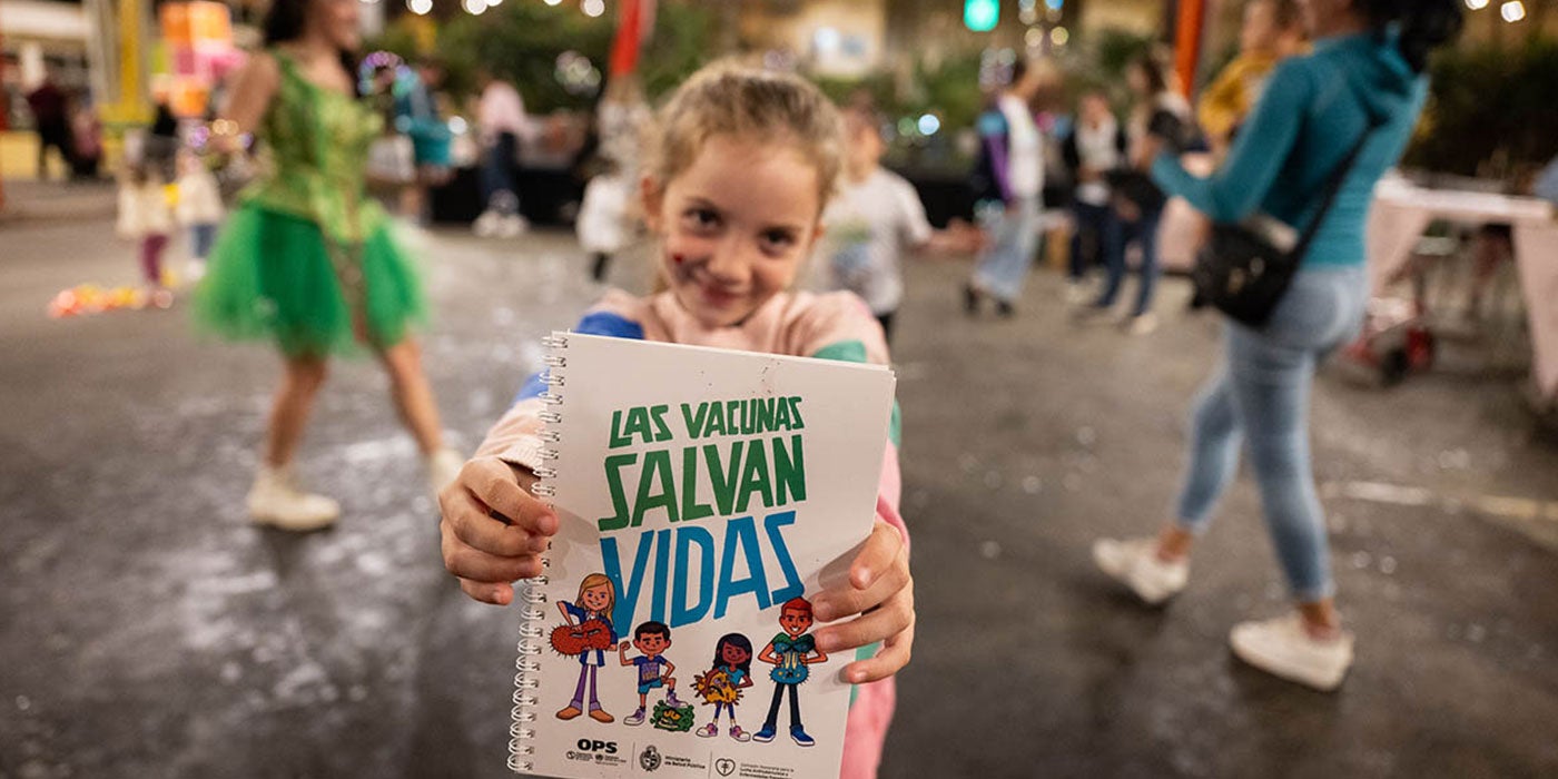 Niña muestra su carné de vacunación