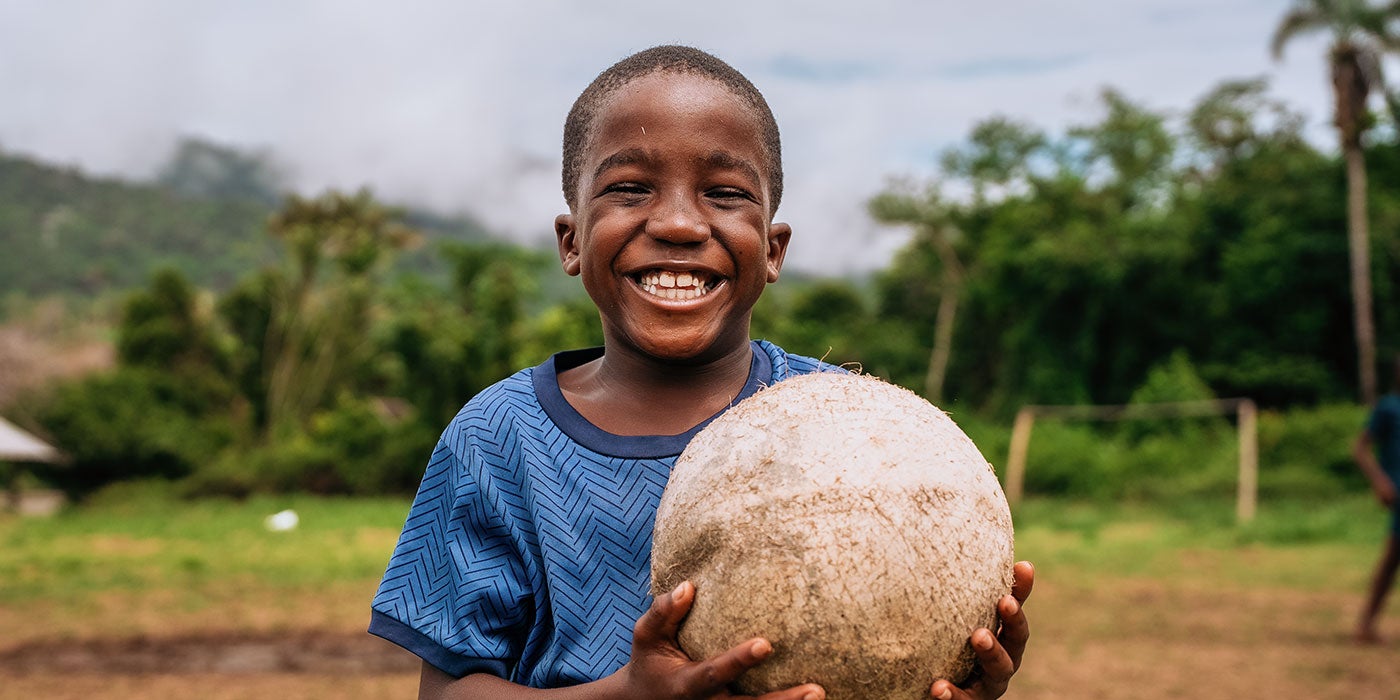 Boy holding worn out ball