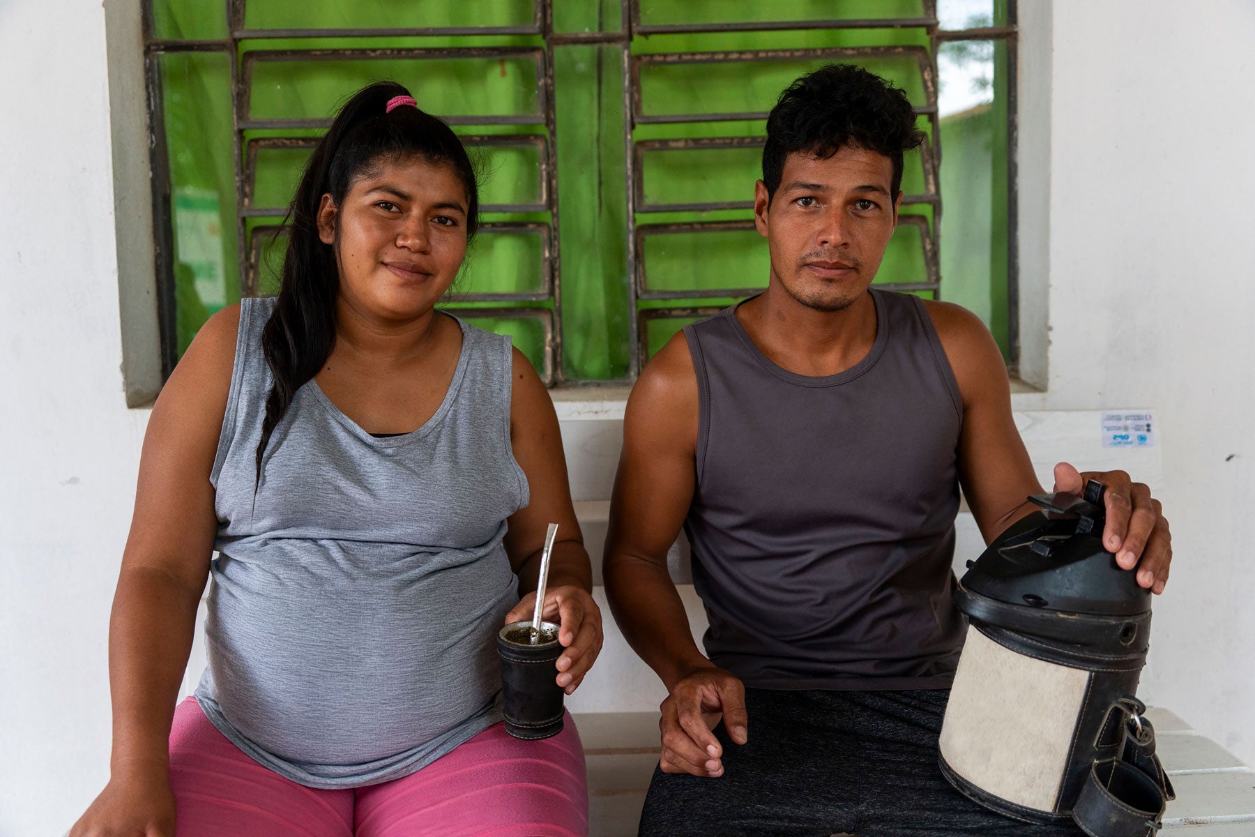 una mujer y un hombre tomando tereré