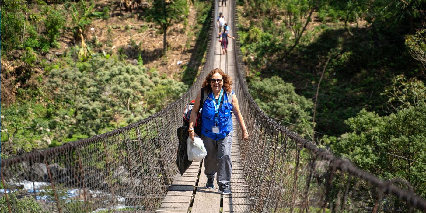 Uma mulher atravessa uma ponte suspensa