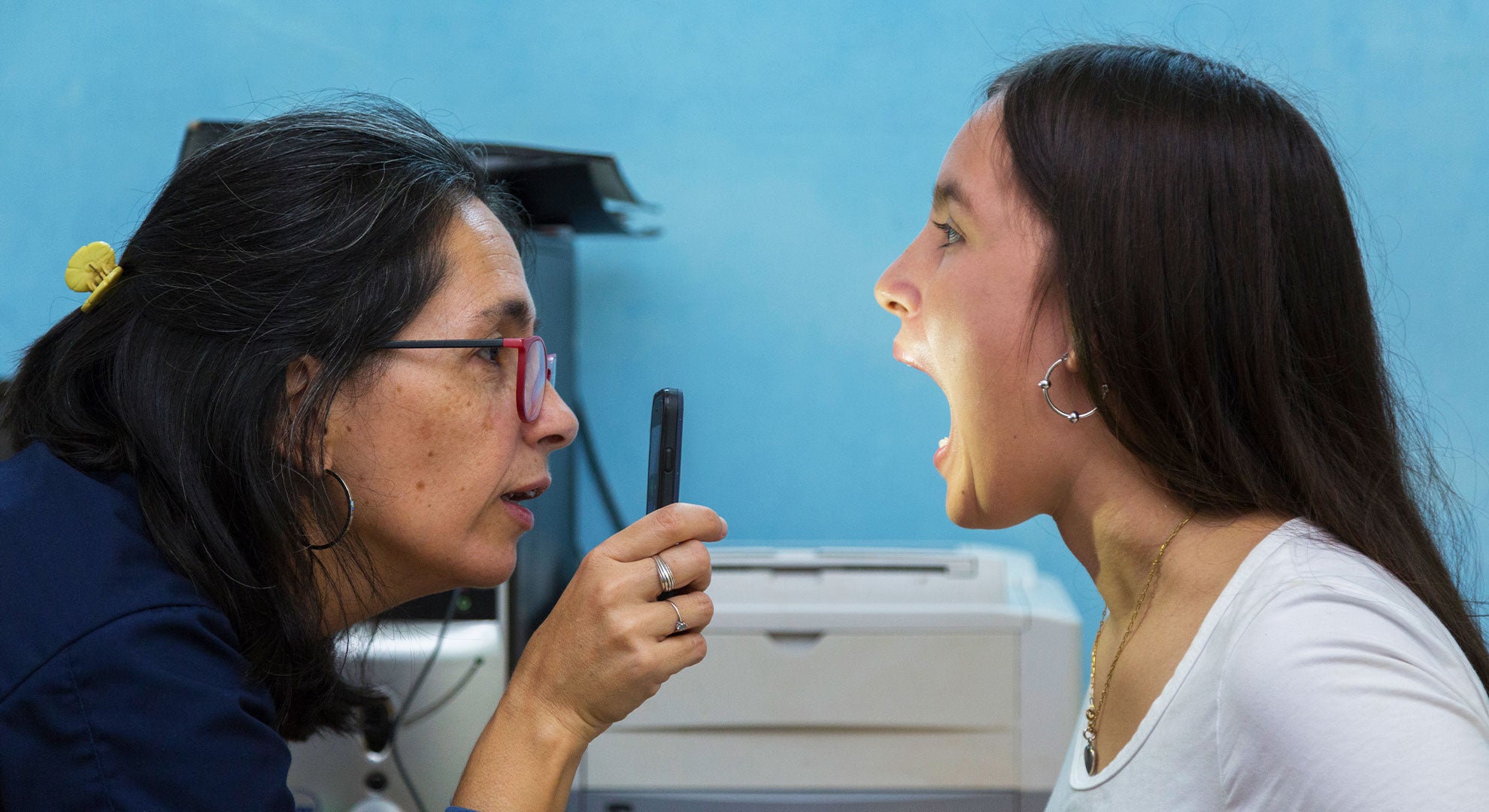 Médico examina la garganta de un adolescente