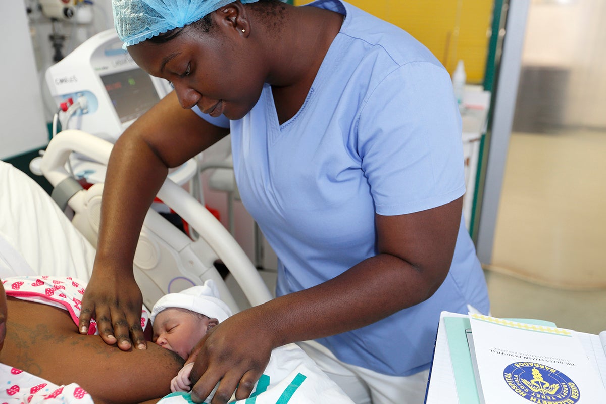Una enfermera del Hospital Queen Elizabeth, en Barbados, muestra las técnicas de lactancia materna a una madre primeriza.