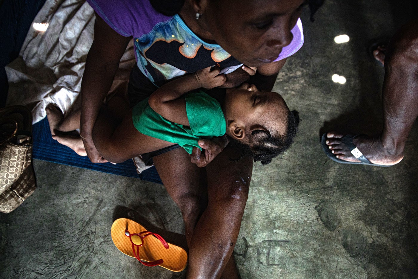 Mother breastfeeding child in camp for those who have been displaced.