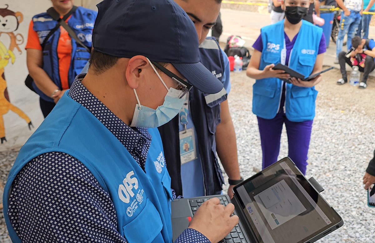 Consultor de la OPS muestra el funcionamiento del Sistema de Vigilancia a personal de la Secretaría de Salud desde una tablet, en una zona remota de Honduras