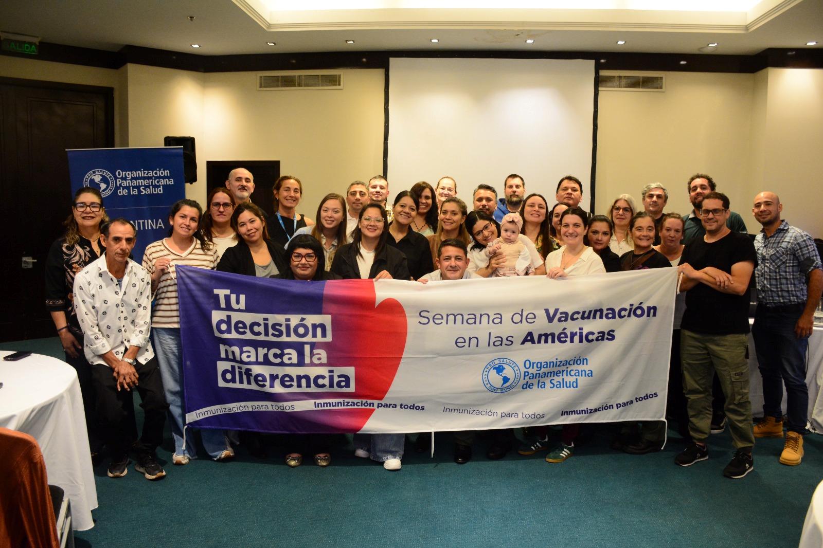 Participantes con la bandera de la Semana de Vacunación en las Américas
