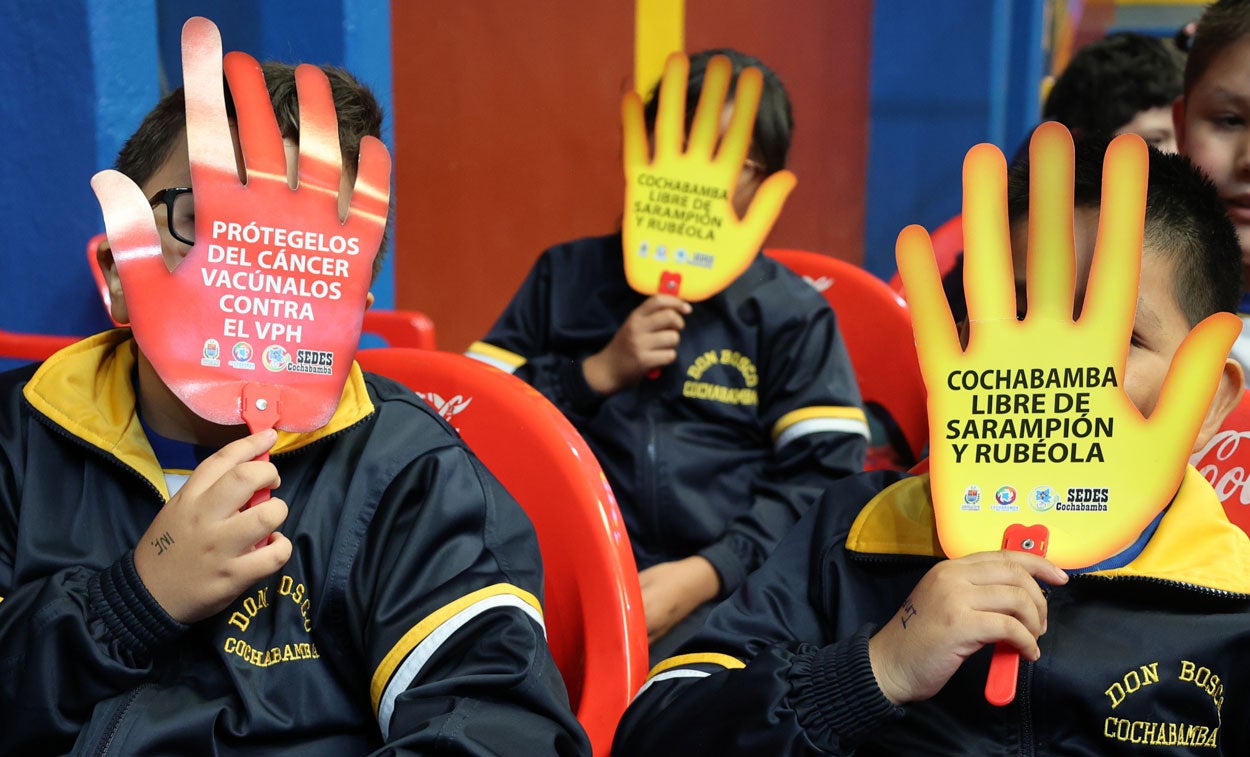 Niños con rótulos promoviendo la vacunación