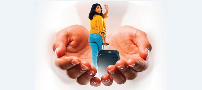 Young woman walks with luggage. Hands embrace her