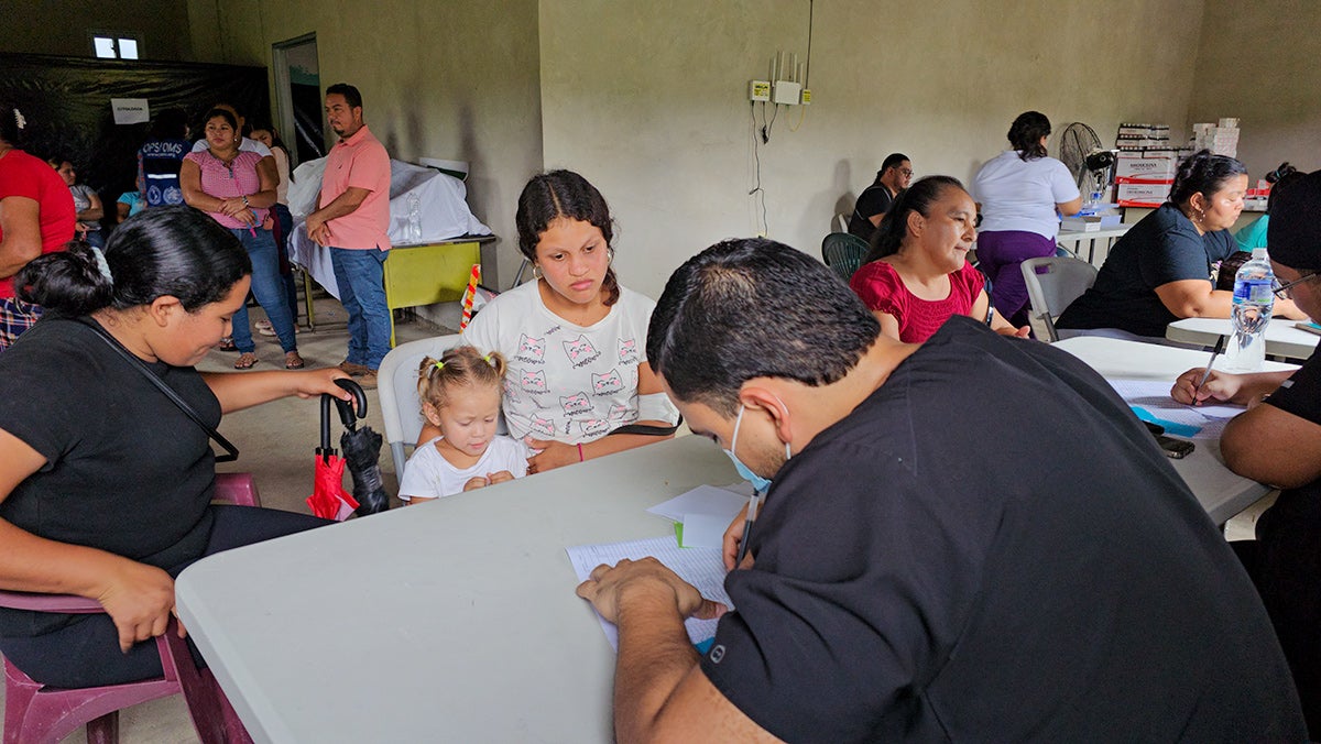 Mercy y Danisley durante la consulta médica en la Cooperativa El Chile. La brigada realizó 308 consultas médicas generales, atendiendo principalmente a mujeres y niños de la población desplazada. © OPS Honduras, 2026