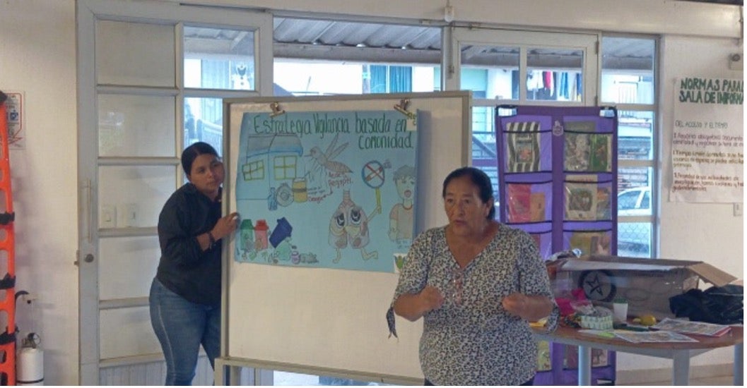 Una señora y un joven, facilitando un taller comunitario