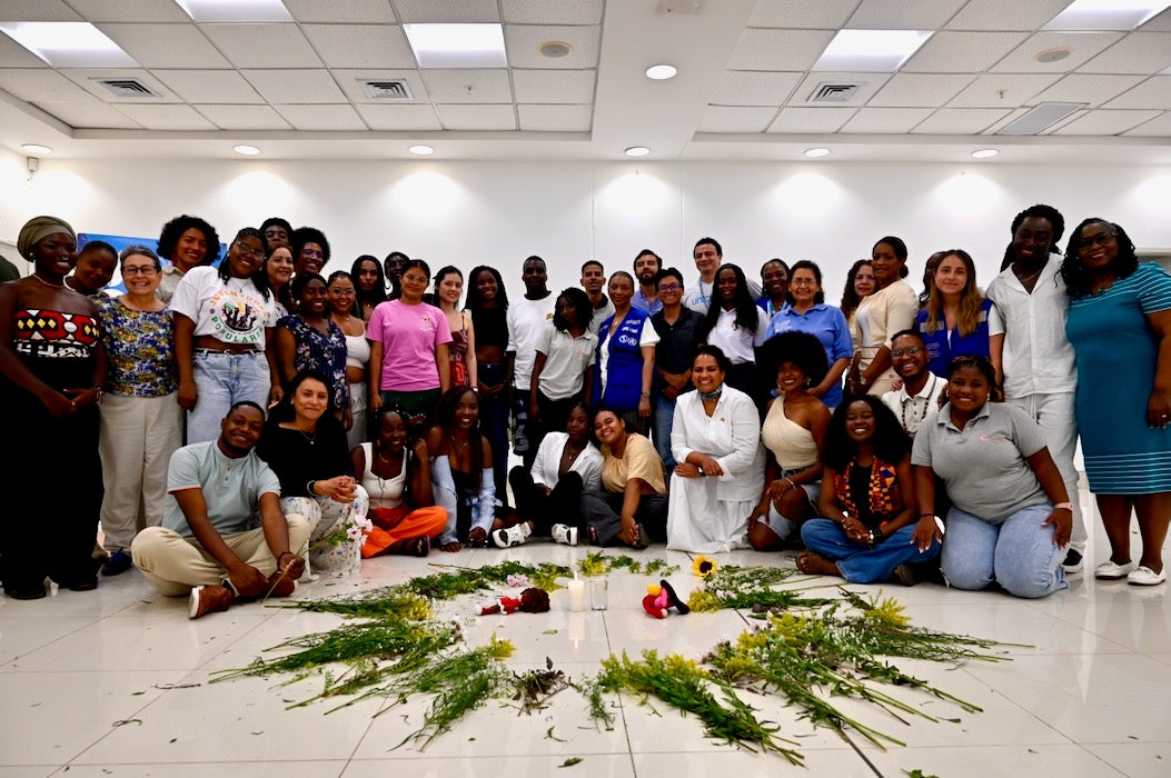 grupo de personas frente a ofrenda de flores