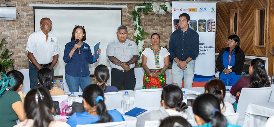 Fotografía de la Dra. Lilian Reneau Gaitán, representante de la OPS/OMS en Panamá, a.i. desarrollando discurso de apertura junto a las autoridades regionales en salud y participantes de la Capacitación de parteras tradicionales.