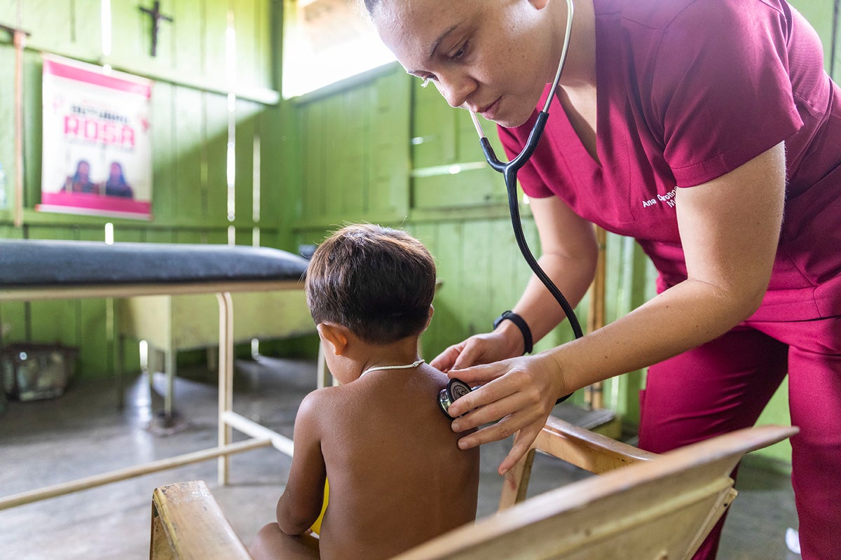 Una trabajadora de salud asiste a un niño indígena en la base de Surucuru, uno de los 37 centros de salud del DSEI yanomami. Foto: Karina Zambrana/MS/OPS/OMS.