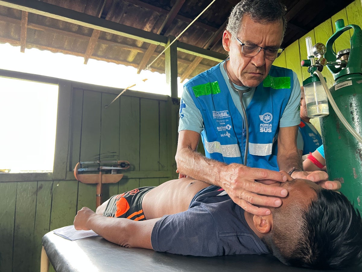 A worker from the Unified Health System’s (SUS) National Force provides healthcare to an indigenous person at the Surucucu base, located at the Yanomami Special Indigenous Sanitary District