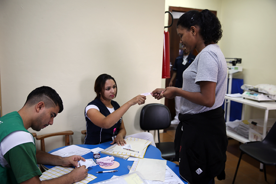 When community residents arrive at their scheduled time, a healthcare professional records their information and makes sure there is no reason they should not get vaccinated, for example, because they are immunocompromised or allergic to eggs.