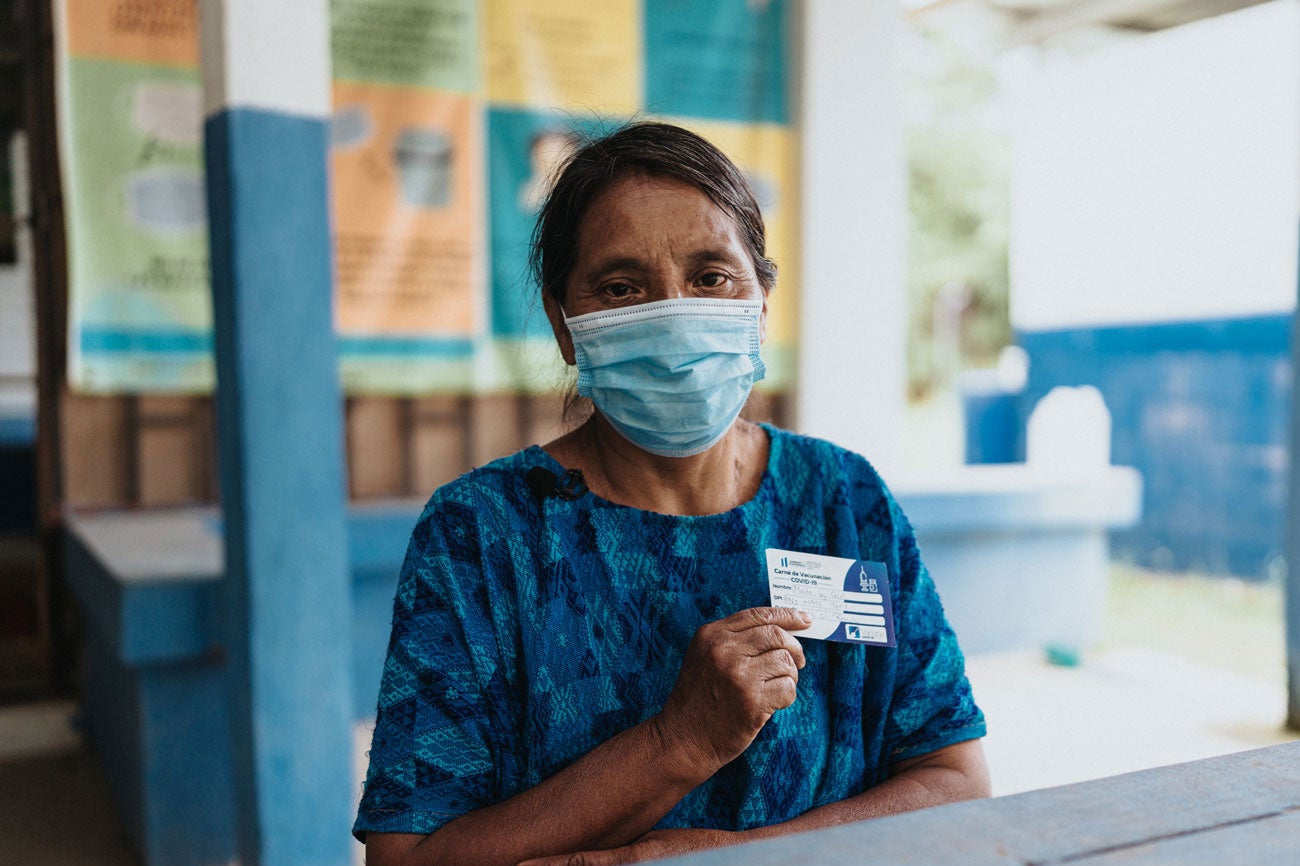 Comadrona Guatemalteca con prueba de vacunación contra la COVID-19
