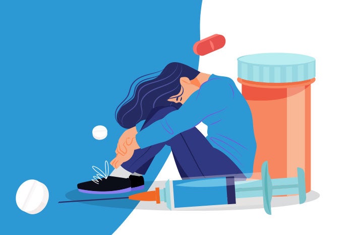 Joven sentado en el piso con la cabeza entre sus manos