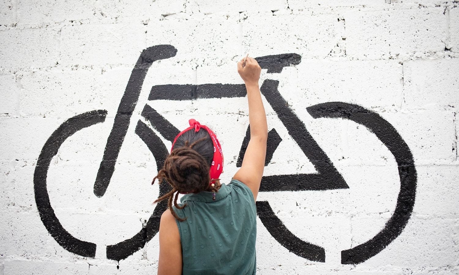 Activista pintando en mural de calle