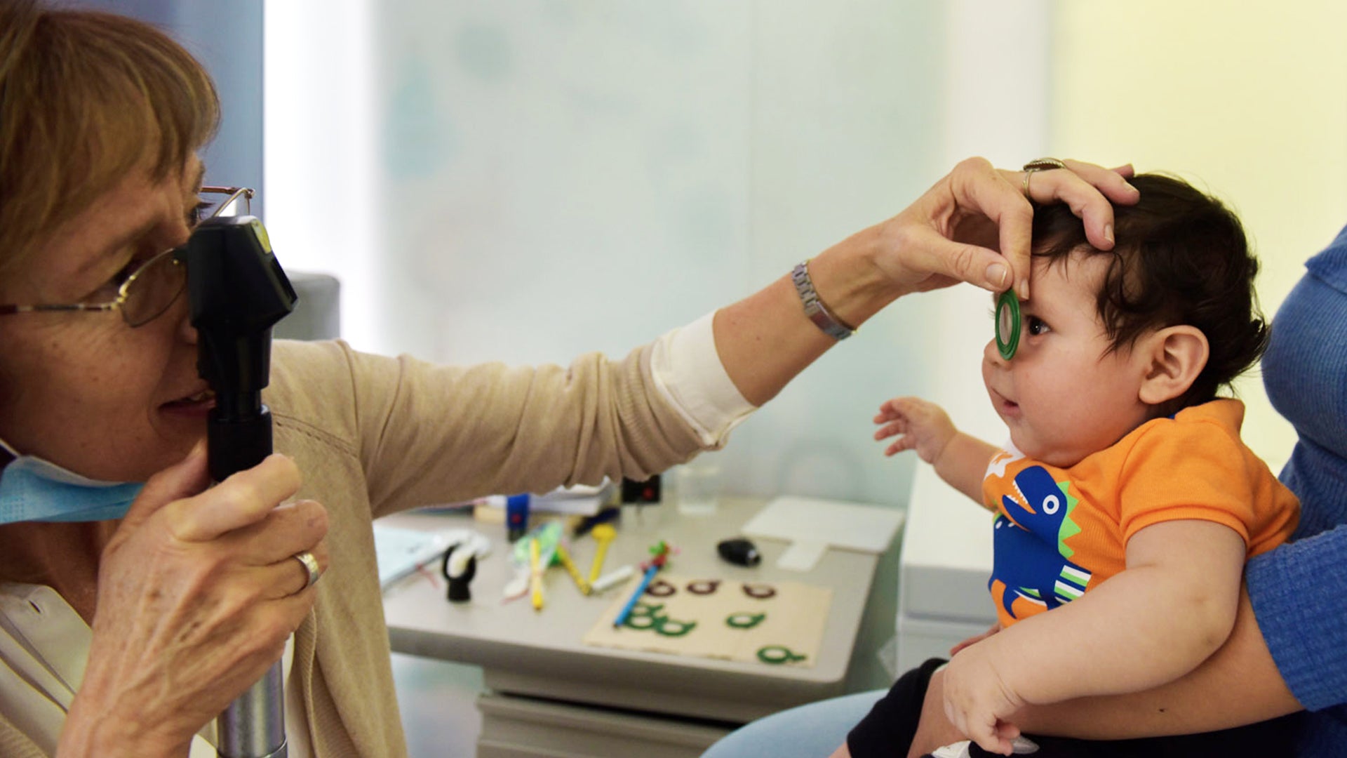 Pediatra revisando los ojos de un bebé