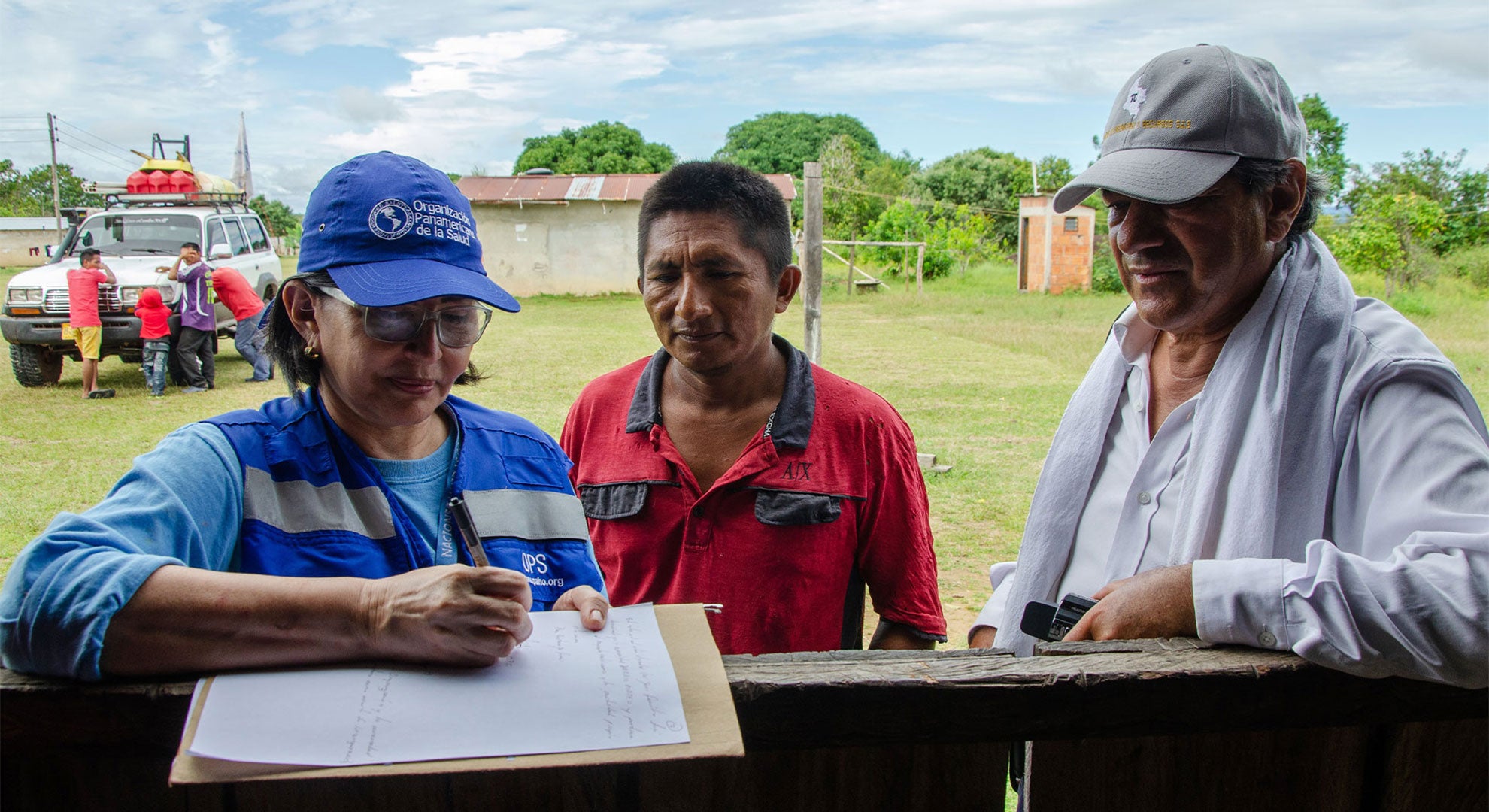 PAHO first responder helping a man sign forms 