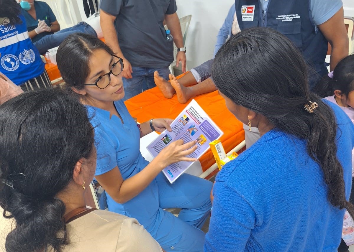 OPS/ Personal de salud en Chulucanas - Piura explica a los familiares de pacientes sobre los cuidados de la lesión, utilizando el material didáctico de la OPS. 