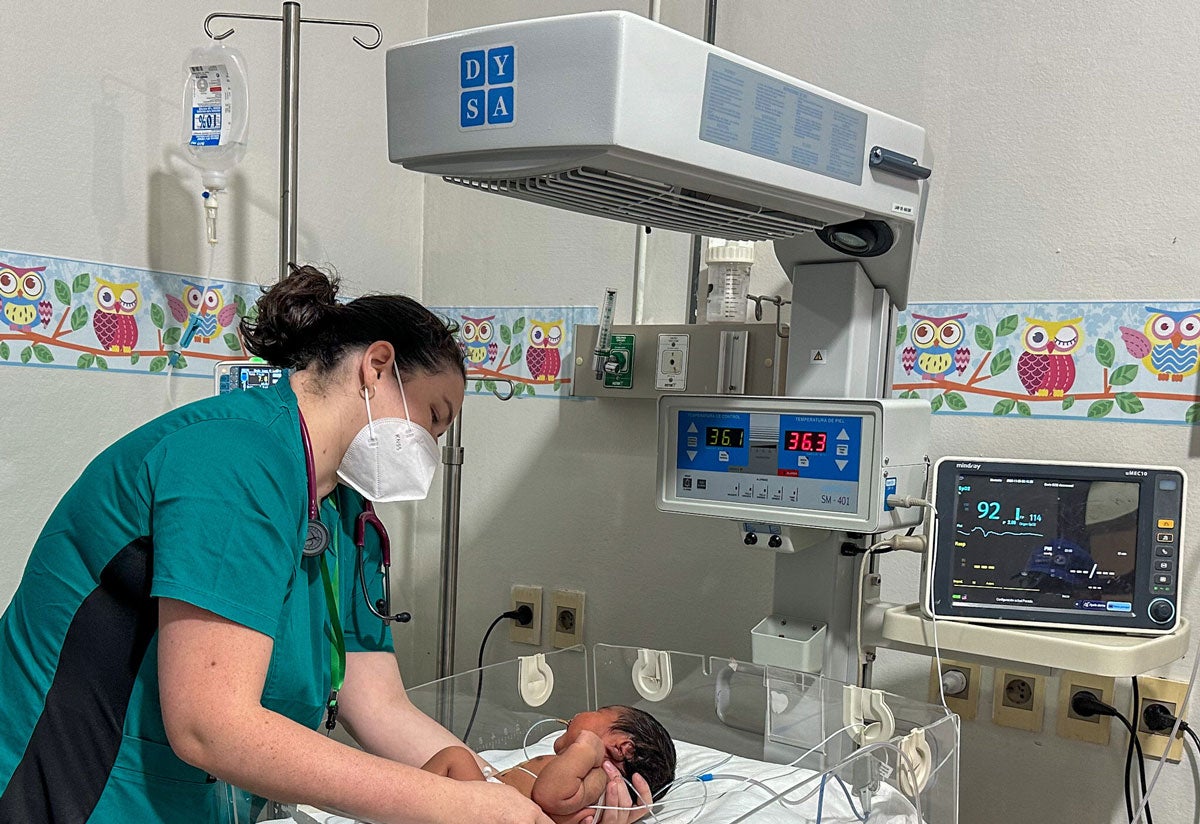 La doctora Jennifer Heyn junto a un recién nacido que duerme tranquilamente en una de las servocunas donadas por la OPS al Hospital Distrital de Curuguaty.