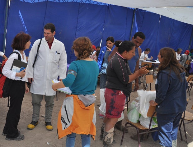 PAHO/WHO Representative Paloma Cuchi talks with members of a Cuban medical brigade who are helping people affected by the flooding