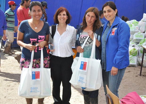 Melisa Fernández Hinojosa, a mother of three in Copiapo, Chile, says she lost everything children during the flooding. In this photo, she and a neighbor receive a hygiene kit from PAHO/WHO Representative Paloma Cuchi and Seremi Atacama Health Director Brunilda González