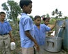 Kids fill pots with drinking water