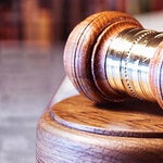 Resting gavel with cigarette packaging in the background