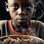 Niño afrodescendiente con un bol lleno de productos de tabaco frente a el, en lugar de comida