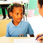 Girl and health worker in a school in Dominican Republic