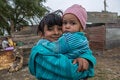 Girls with baby in her hands in impoverished area