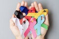 Hands with ribbon of the different colors representing various cancer types