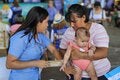 Enfermera junto a madre y niño vacunado
