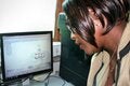 Mujer de perfil mirando la pantalla de una computadora donde se ve el SIP