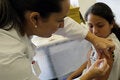 Healthcare professional vaccinates a teen girl in the arm against HPV