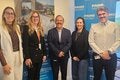 Delegação da Secretaria de Saúde de São Paulo e equipe da OPAS/OMS posam no Centro de Operações de Emergência, ao lado de um banner sobre resposta a emergências em saúde.