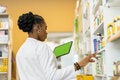 Female pharmacist checking the medicine on shelfs in drugstore