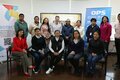 participantes de taller posan para foto junto a banners del evento