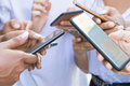 Jóvenes usando teléfonos inteligentes en la calle. Amigos pensativos usando dispositivos digitales en la plaza de la ciudad. Comunicación, concepto de tecnología.