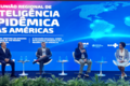 Panelistas sentados con fondo alusivo al evento, mostrando mapa mundi y título del evento